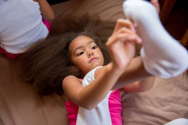 A girl putting on one of her socks